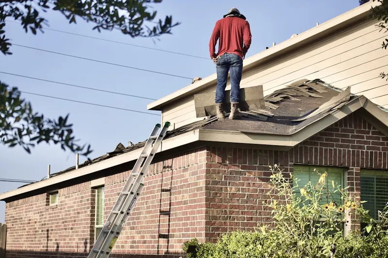 Professional roofer working on a residential roof in Century Oaks West